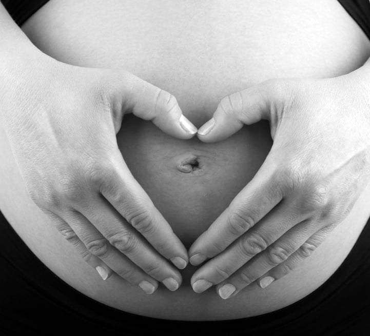 Pregnant Woman Making Heart Hand Gesture on Belly